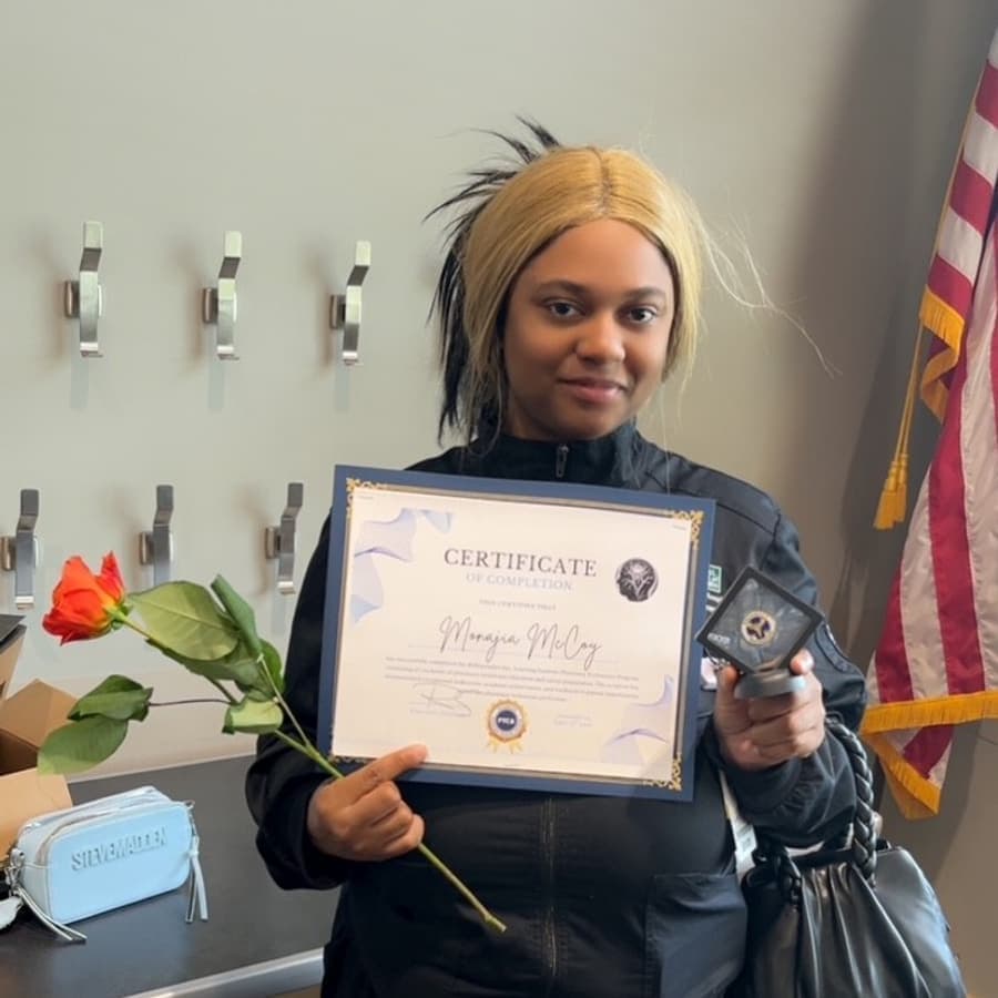A Brilliantaires graduate celebrating with her certificate
